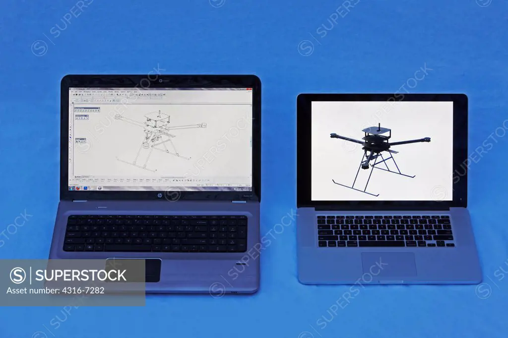 Two computers, one showing computer aided design (CAD) rendering of prototype experimental unmanned aerial vehicle (UAV), and another showing photograph of completed UAV