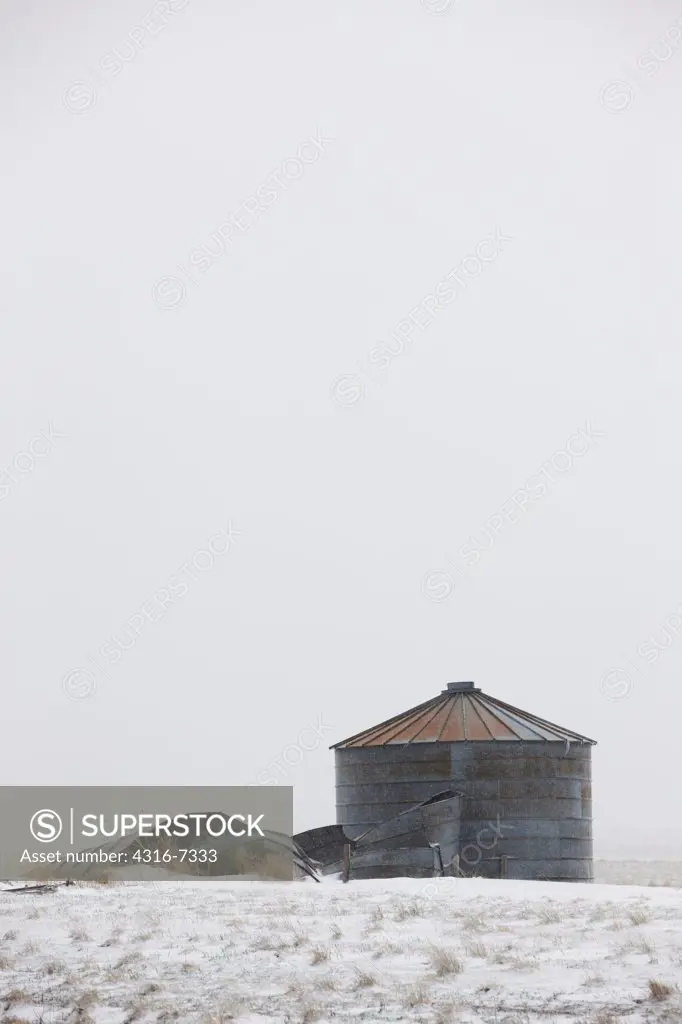 USA, Colorado, Eastern Plains of Colorado, Abandoned, decaying grain storage bins during blizzard