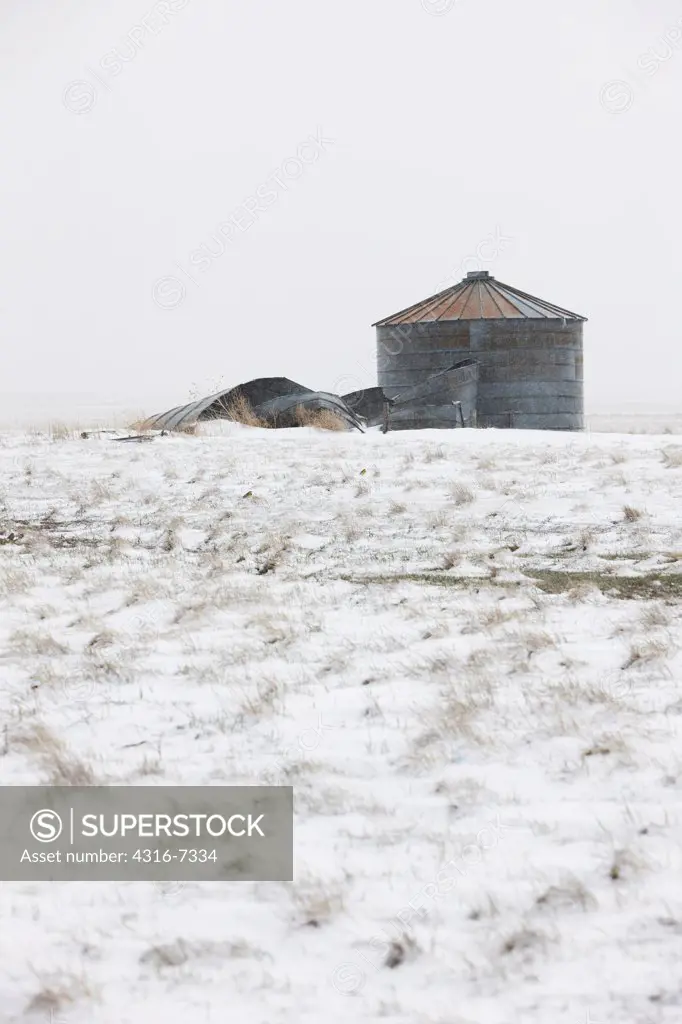 USA, Colorado, Eastern Plains of Colorado, Abandoned, decaying grain storage bins during blizzard