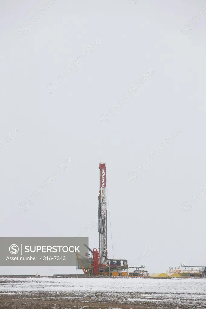 USA, Colorado, Eastern Plains of Colorado, Oil well pump drilling rig, using hydraulic fracturing (called fracking or hydrofracking) during blizzard