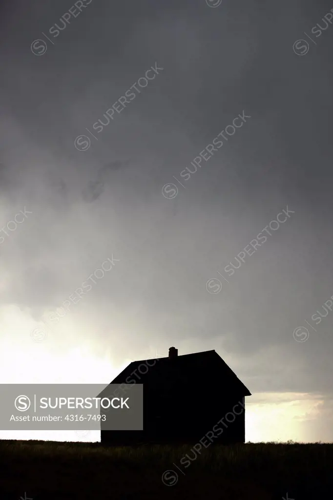 Silhouette of an abandoned, Dust Bowl era school house during an intense thunderstorm that spawned a funnel cloud, Colorado