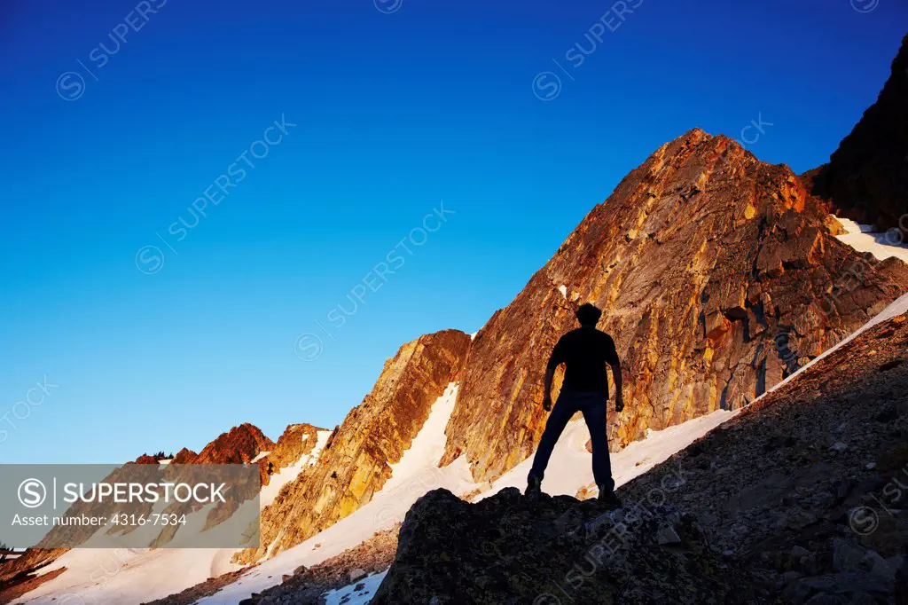 Silhouette of man below soaring, steep mountain peaks, Snowy Range, Medicine Bow Mountains, southern Wyoming