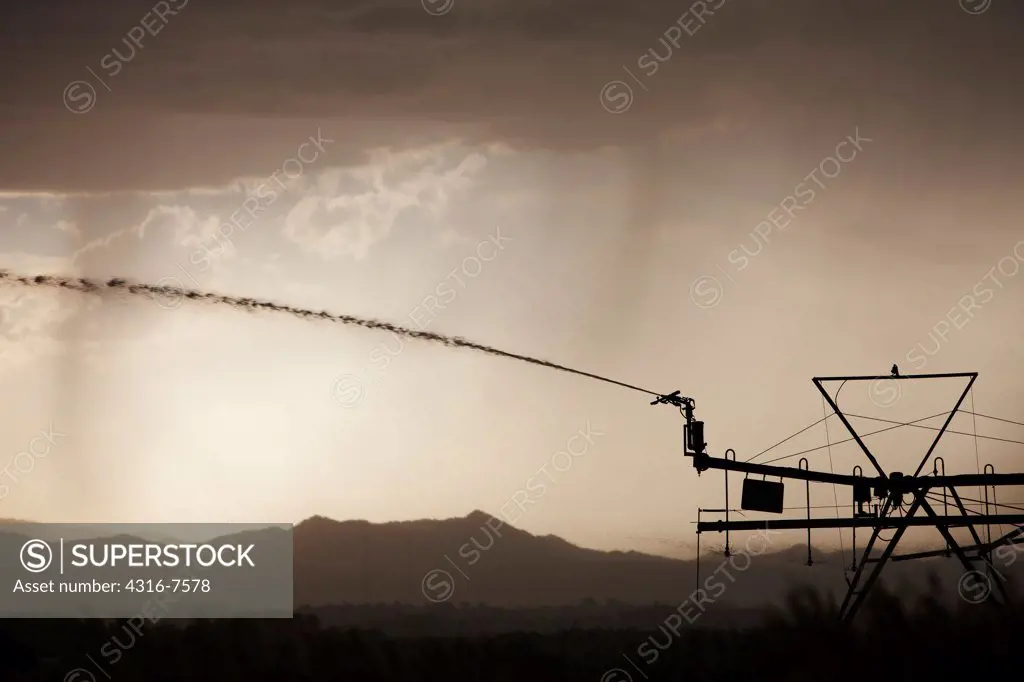 Center pivot end gun water sprayer on center pivot irrigation arm, approaching thunderstorm, Colorado