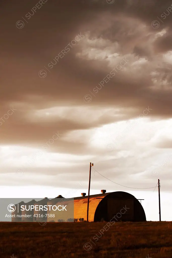 Grain storage bins at sunset after the passage of a powerful thunderstorm, Colorado