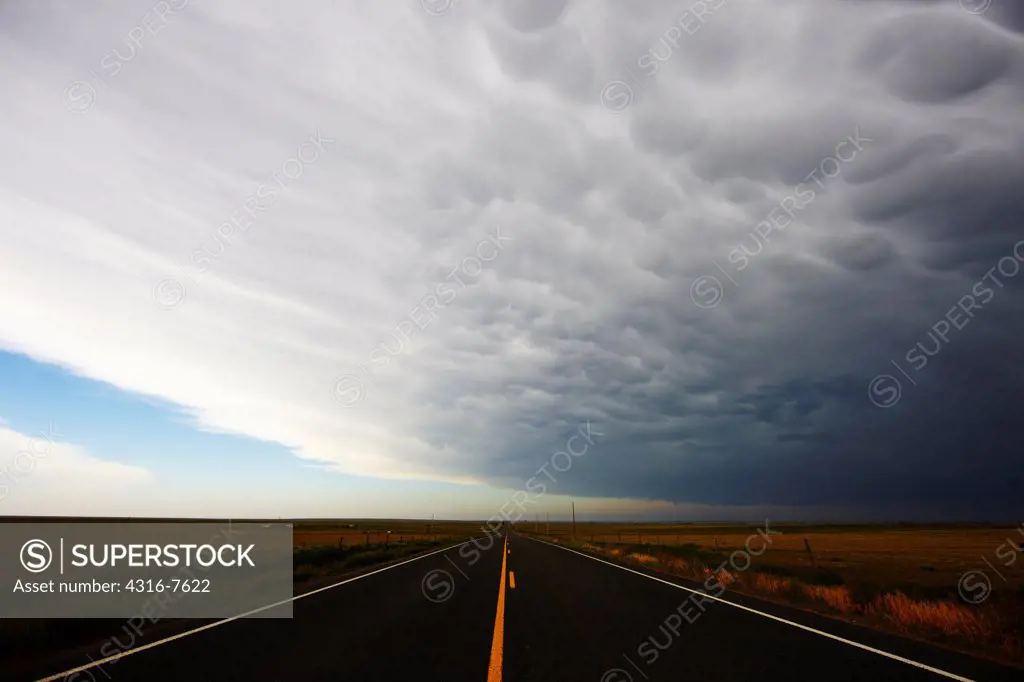 Massive thunderstorm, showing mammatus cloud forms over highway, Colorado