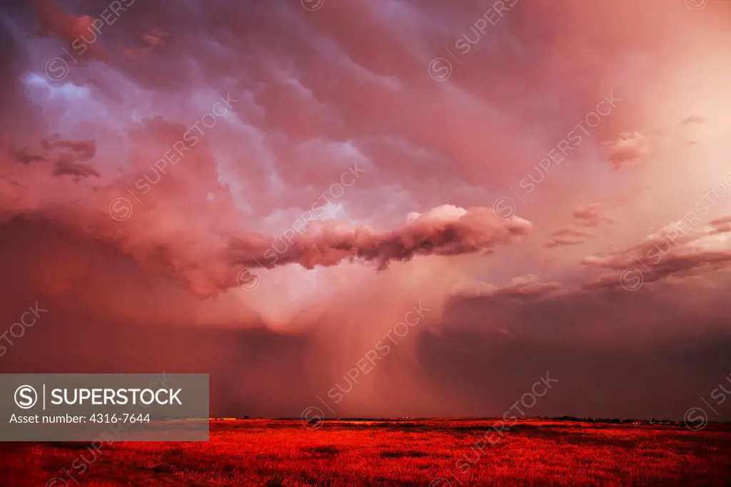 Sunset light on a powerful thunderstorm dropping dense rain over the eastern plains of Colorado