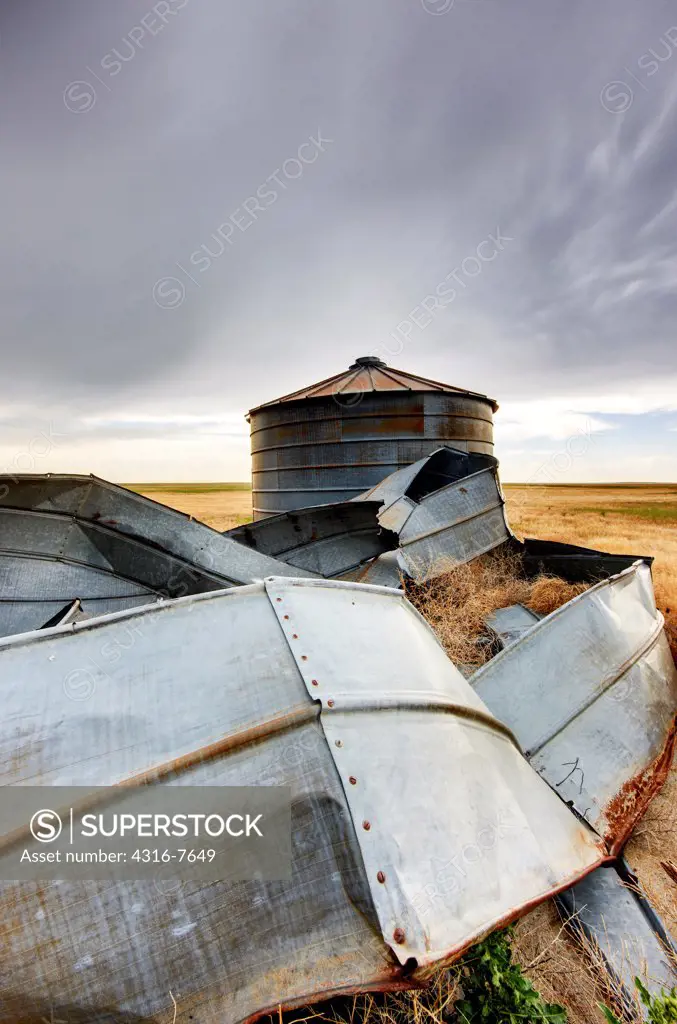 Old, decaying grain bins, destroyed by wind and other elements, on open plains of eastern Colorado