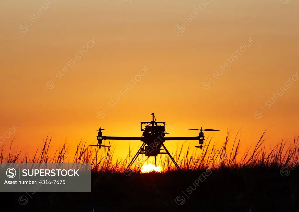 Small unmanned aerial vehicle (UAV), Also called drone, Prepared for launch, Silhouetted by rising sun
