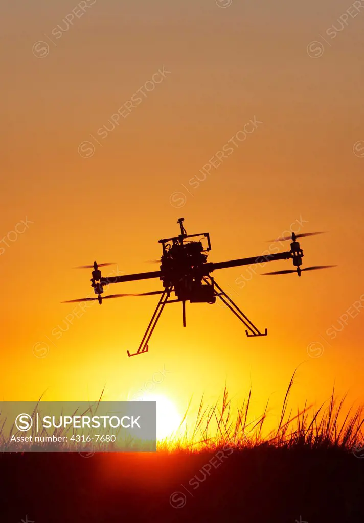 Unmanned aerial vehicle (UAV) or drone, In flight, Silhouetted by rising sun