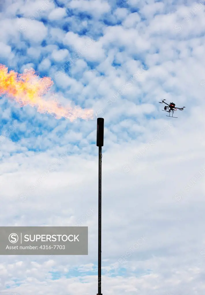 Unmanned aerial vehicle (UAV) or drone inspecting natural gas flaring tower