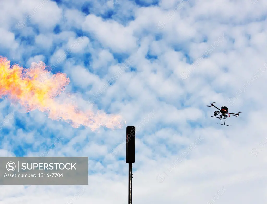 Unmanned aerial vehicle (UAV) or drone inspecting natural gas flaring tower