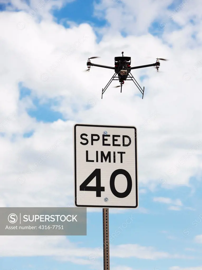 Drone, Or Unmanned Aerial Vehicle (UAV) flying above speed limit sign, As if enforcing speed limit