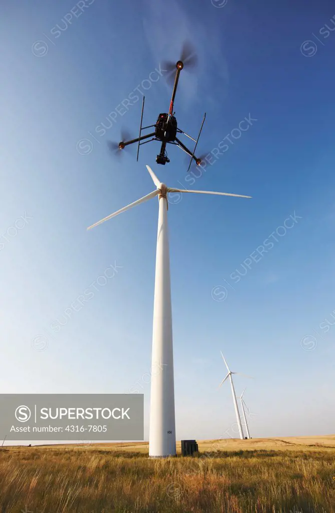 Unmanned Aerial Vehicle (UAV) hovering below a spinning wind turbine, Colorado, USA