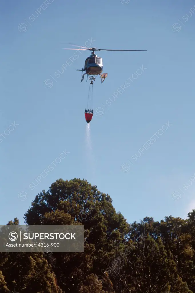 A Firefighting Helicopter Carries a Fresh Load of Water to a Conflagration