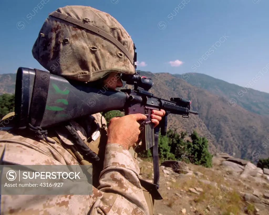 A US Marine Scans the Mountainous Countryside Through the Sights of His M-16