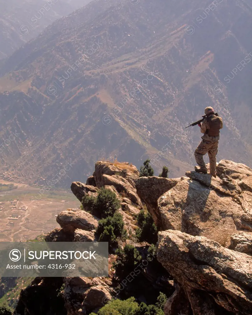 A US Marine Scans the Mountainous Distance Through the Sight of His M-16