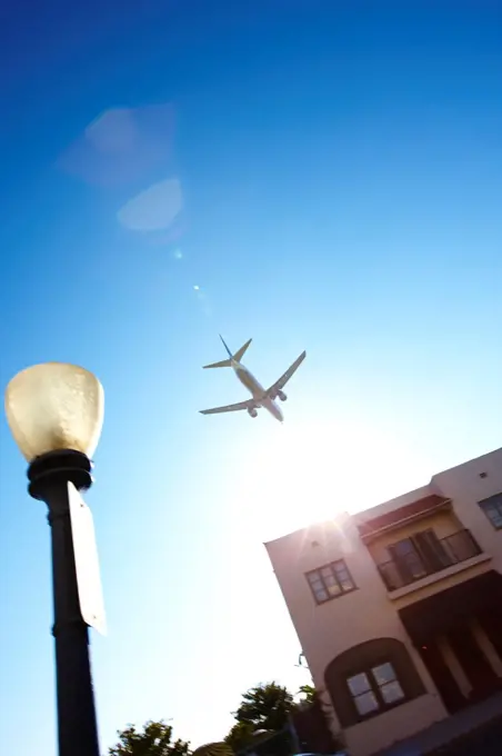 USA, California, San Diego, Jet airliner flying low over apartment complex