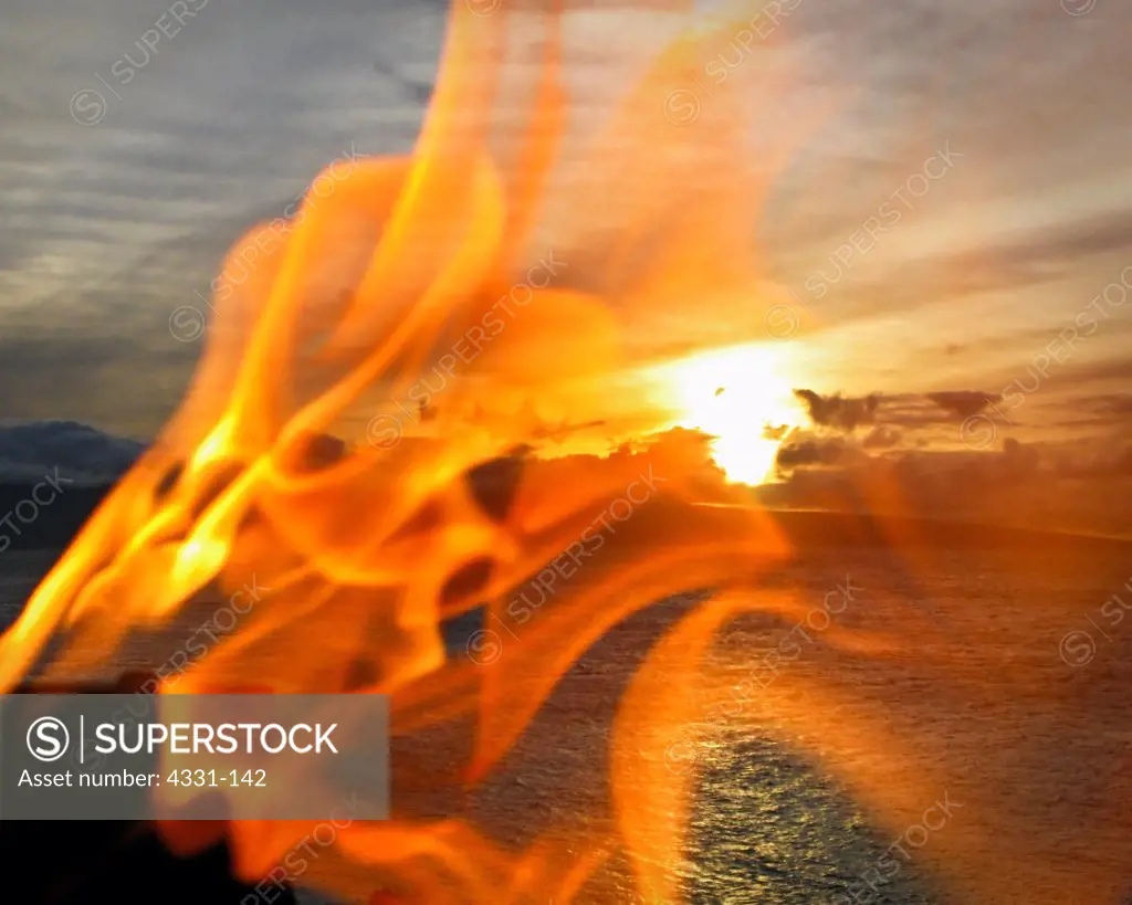 This is part of the sunset torch lighting ceremony at Black Rock in Maui. Black rock is in the town of Lahaina. In the background is the island of Lana'i.
