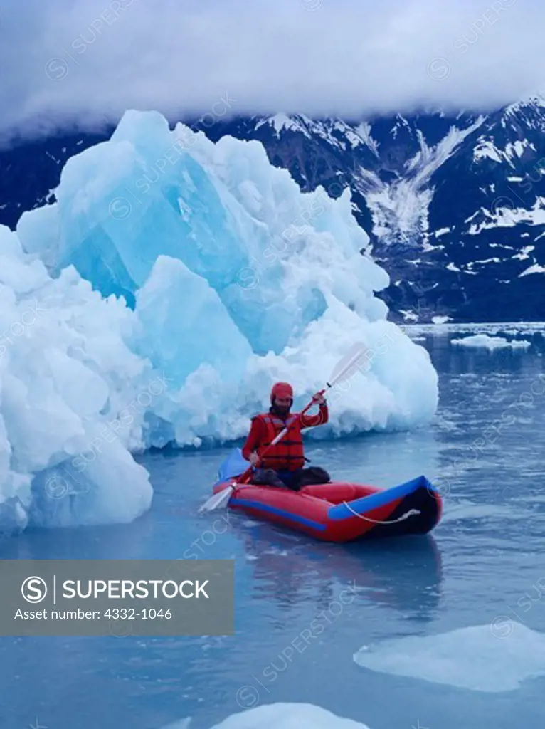 Jeff Gnass paddling inflatable kayak past icebergs calved from the Hubbard Glacier, Disenchantment Bay, Russell Fiord Wilderness, Alaska Maritime National Wildlife Refuge and Wrangell St. Elias National Park, Alaska.