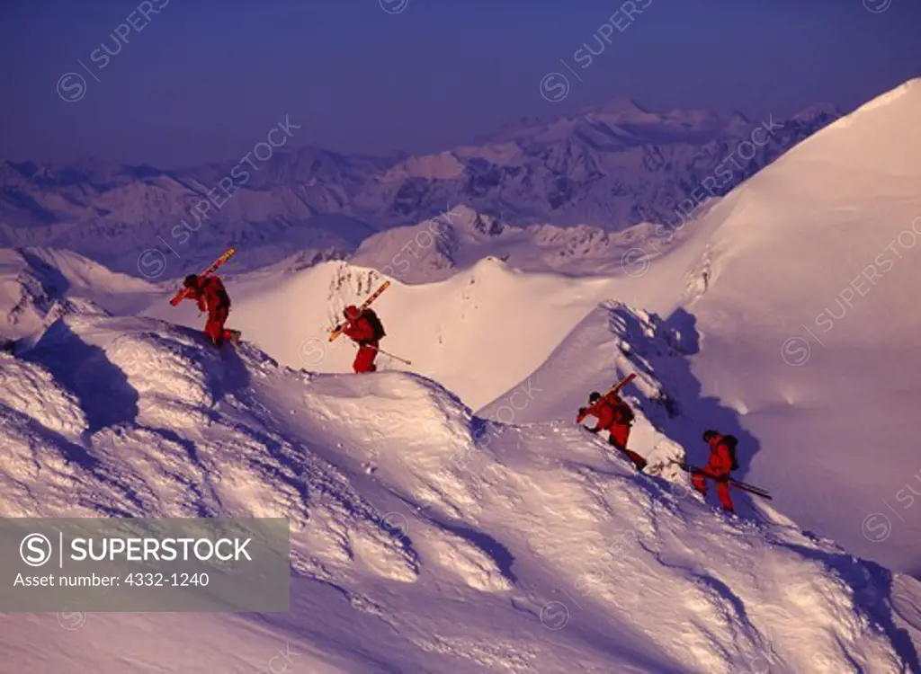Aerial view of helicopter supported backcountry skiers hiking ridge to start their descent in the Chugach Mountains north of Alyeska, Chugach Powder Guides, Girdwood, Alaska.