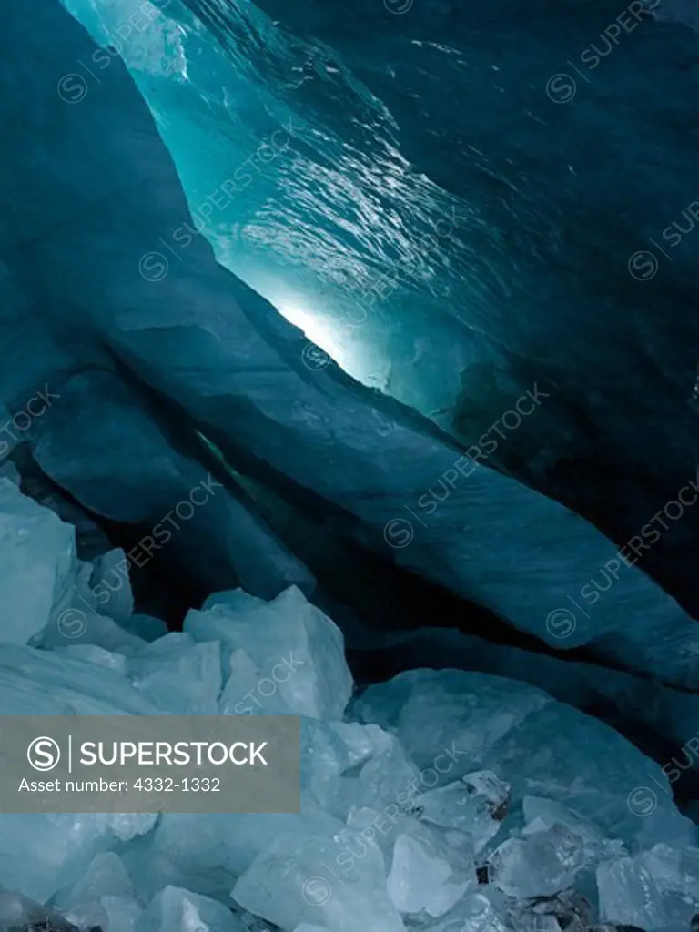 Fin of sculpted blue ice in large ice cave within 'Moulin Glacier' with ice boulders on floor from earlier ceiling collapse, Chugach Mountains, Alaska.