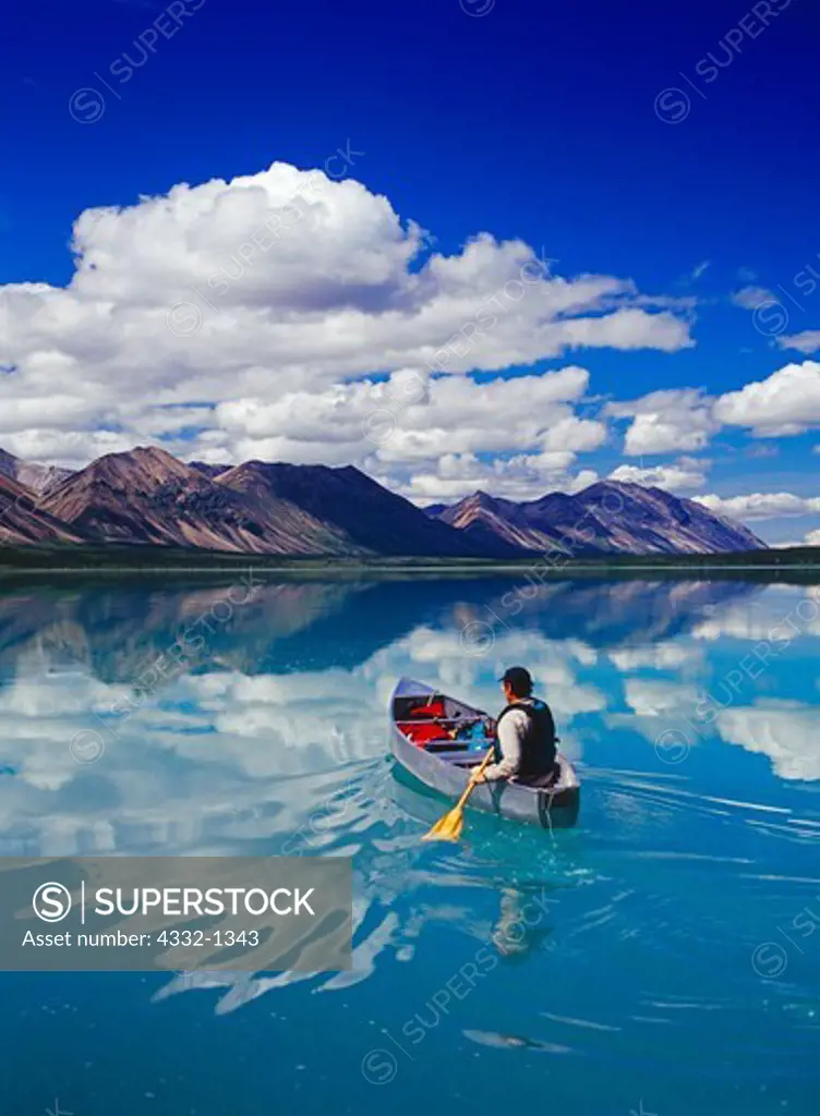 USA, Alaska, Lake Clark National Park, Upper Twin Lake, Man paddling Grumman canoe on glassy water