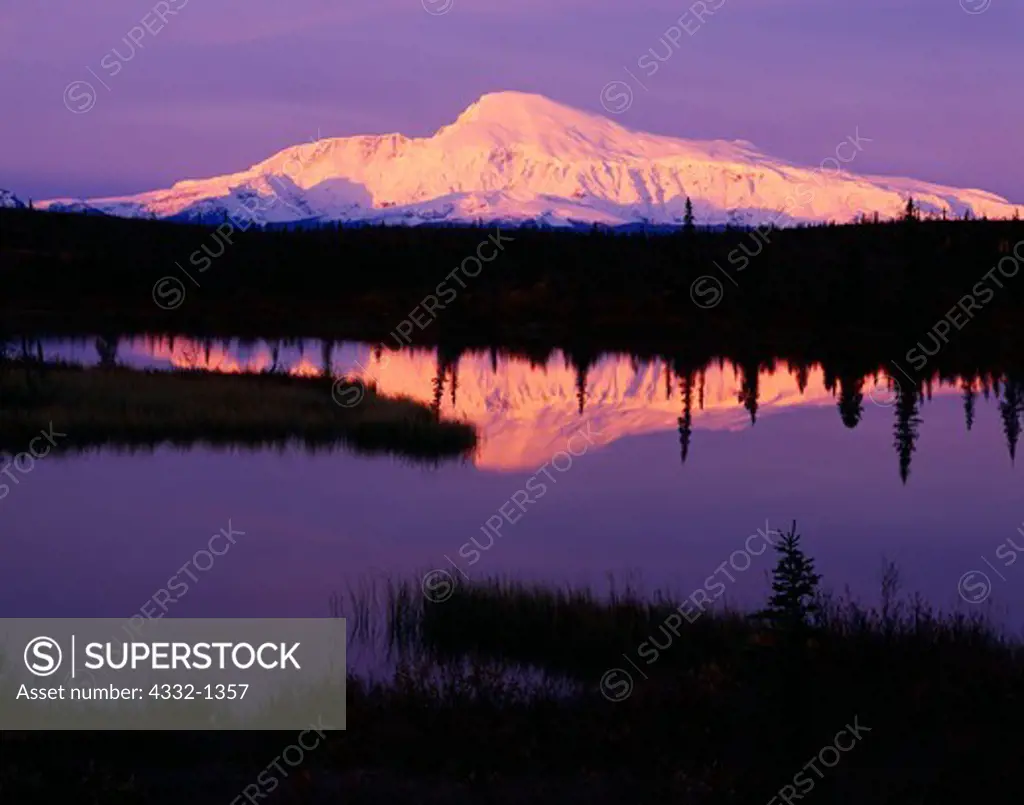 Volcanic summit of Mount Sanford reflected in the still waters of Rock Lake at sunrise, Wrangell-St. Elias National Park and Preserve, Alaska.