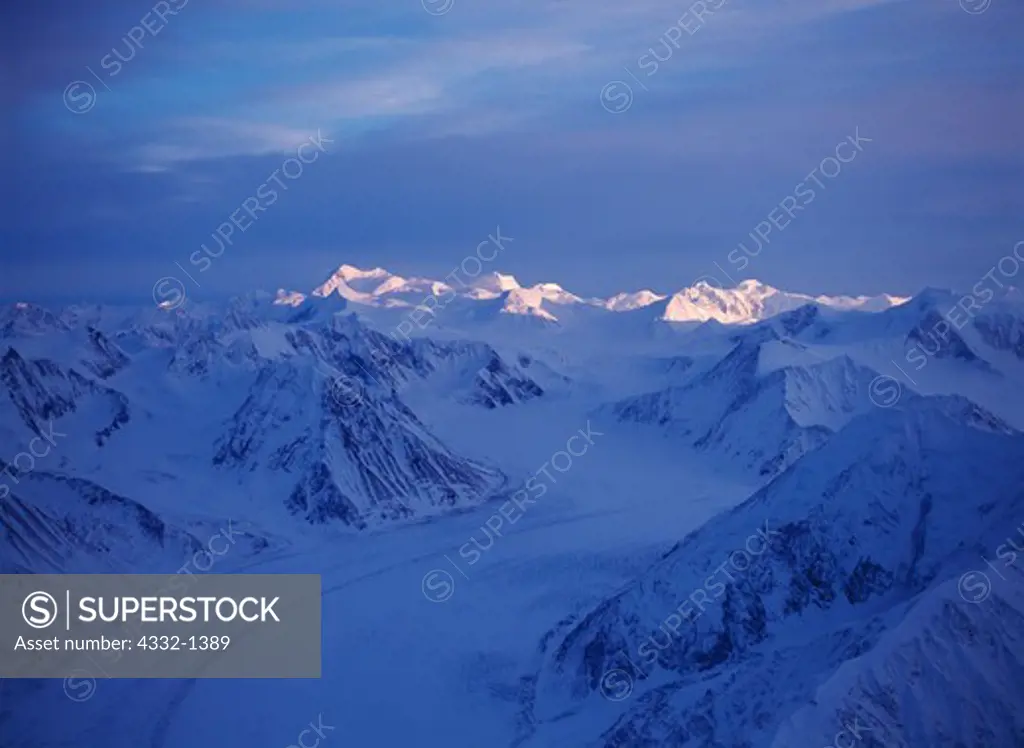 Aerial view of sun illuminating high peaks of the Chugach Mountains at the head of the Matanuska Glacier, Alaska.