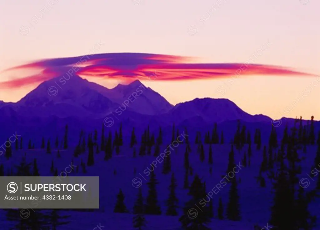 Winter view from Broad Pass of sunset light illuminating lenticular clouds above the Churchill Peaks of 20,320 foot Mount McKinley (Denali) in Denali National Park, Alaska.