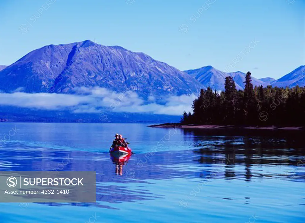 German visitors John Nordstrom and Helmut Niedertscheider paddling an Aire Traveler inflatable canoe down Lake Clark, Lake Clark National Park, Alaska.