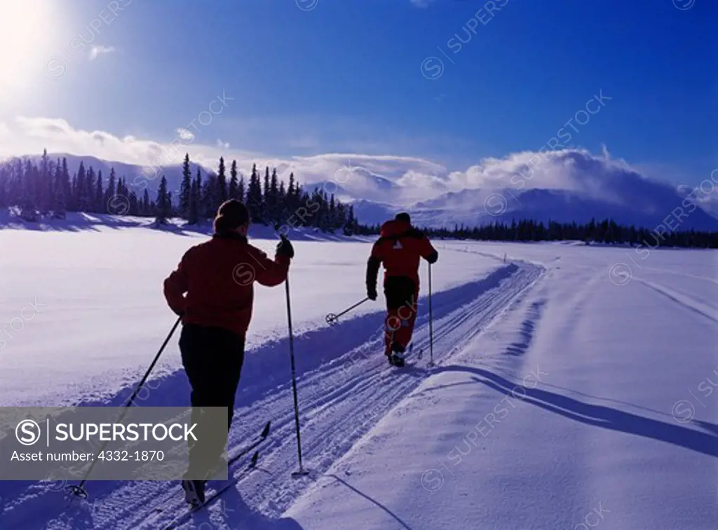 Carl Dixon and Blair Aubrey cross-country skiing on Finger Lake, east side of the Alaska Range, Alaska.