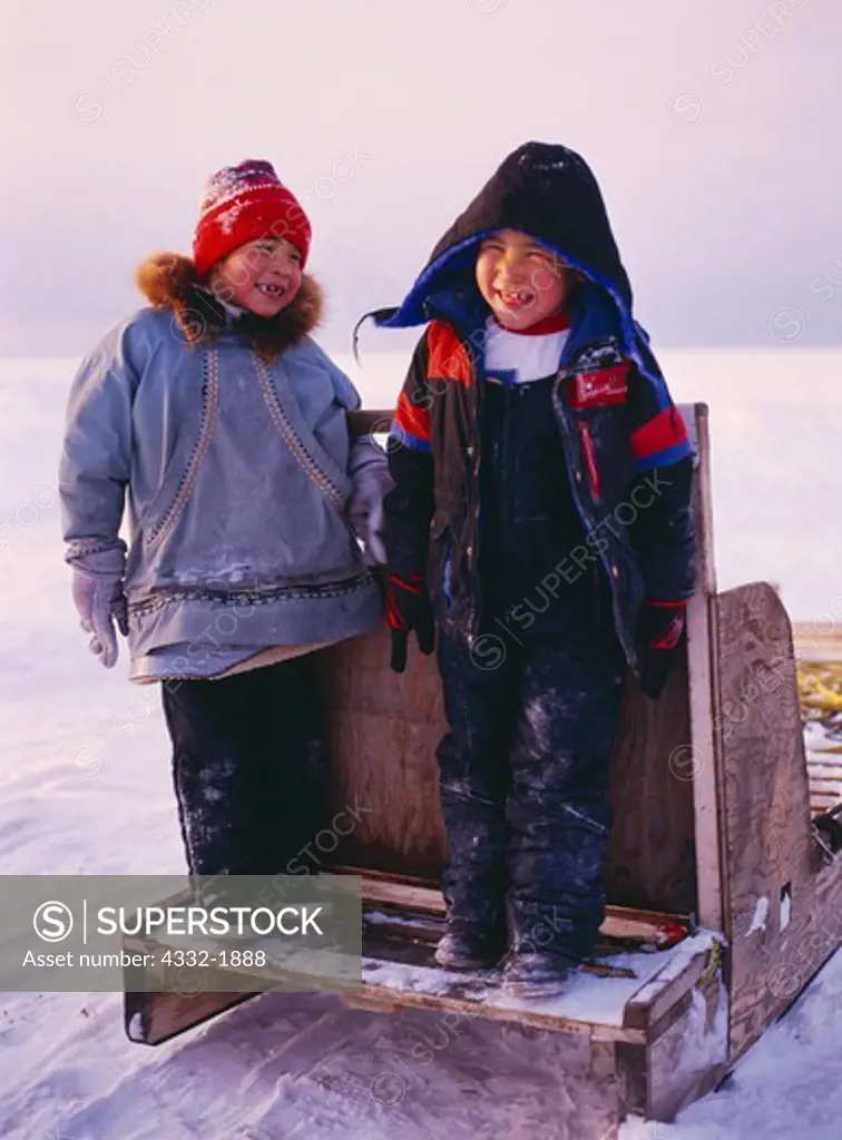 Inupiat children rodney and Jonna playing on sled, village of Wainwright, Arctic Coast of Alaska.