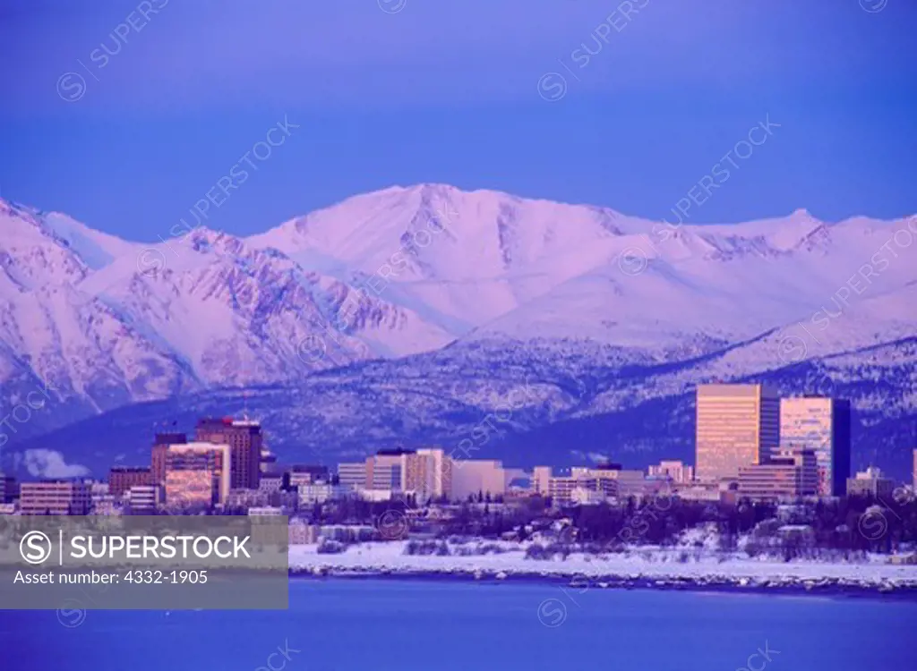 Skyline of Anchorage at dusk with the Chugach Mountains beyond, Earthquake Park on Cook Inlet, Alaska.