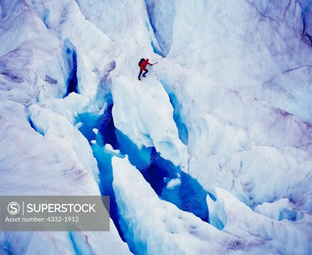 Aerial view of ice climber from helicopter supported Northstar Trekking exploring icefall with blue pool on the Mendenhall Glacier, Tongass National Forest, Alaska.