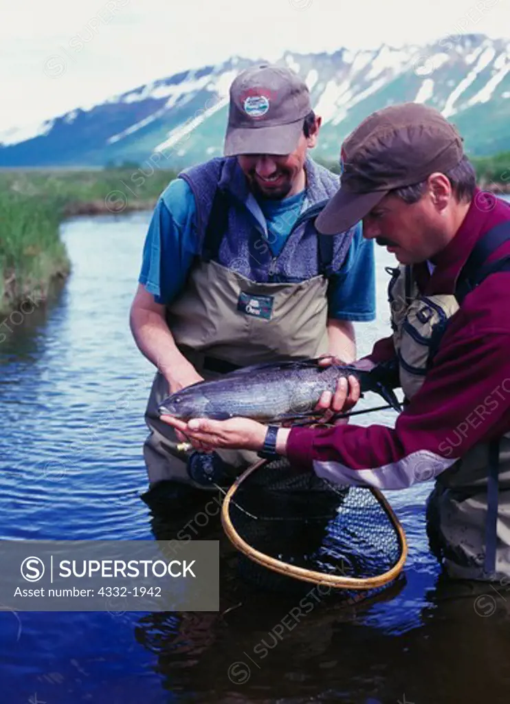 Kris McHugh and Dan Michels gently handling grayling caught by bly fishing on 'Oxbow Creek' northeast of Togiak, Crystal Creek Lodge trip, Alaska.   (MR)