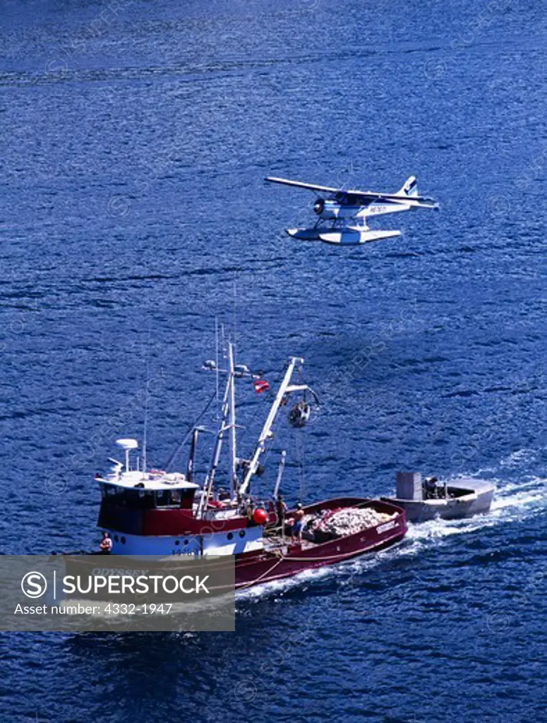 A seiner, the 'Odyssey,' traveling up Tongass Narrows with a Taquan Air Service Beaver above, Ketchikan, Alaska.