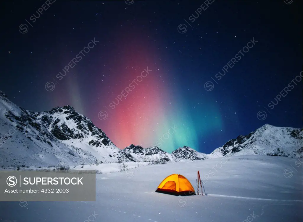 Tent with green and red aurora above the moonlit Talkeetna Mountains near Hatcher Pass during geomagnetic storm on the night of November 6, 2001, Alaska.