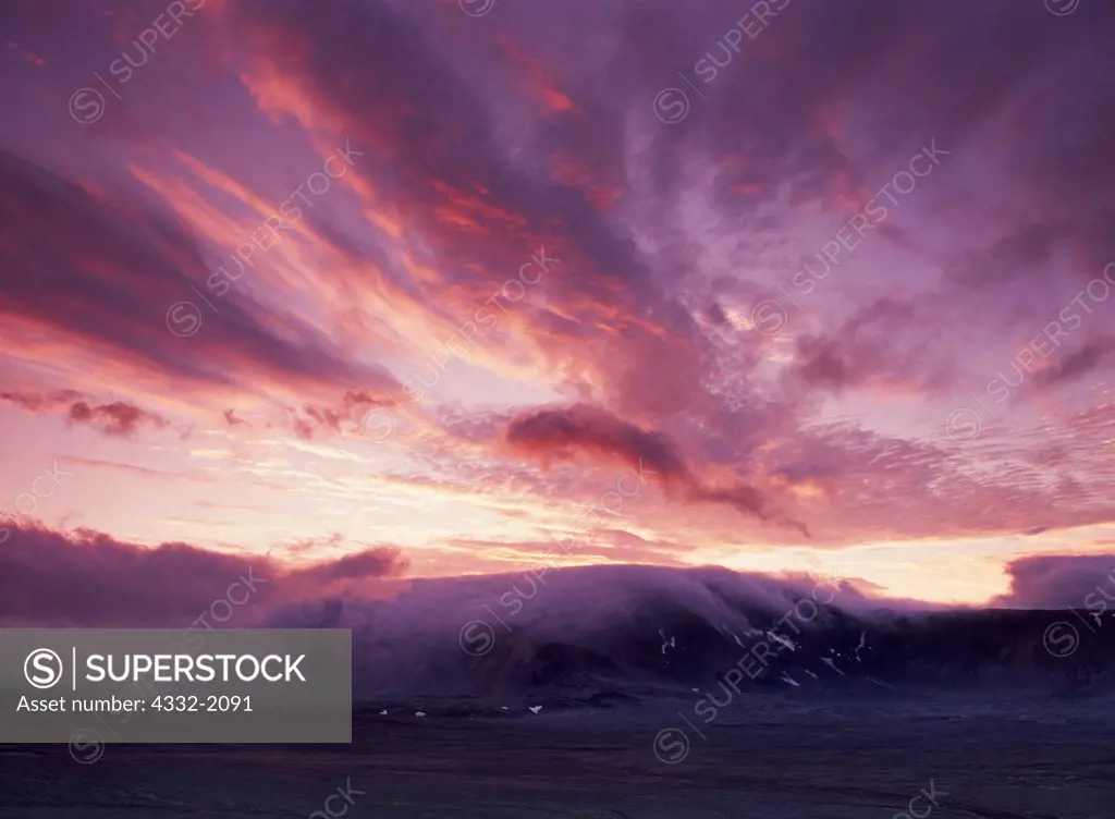 Dramatic sunset as cloud niagaras spills into Aniakchak Caldera, Aniakchak National Monument, Alaska.