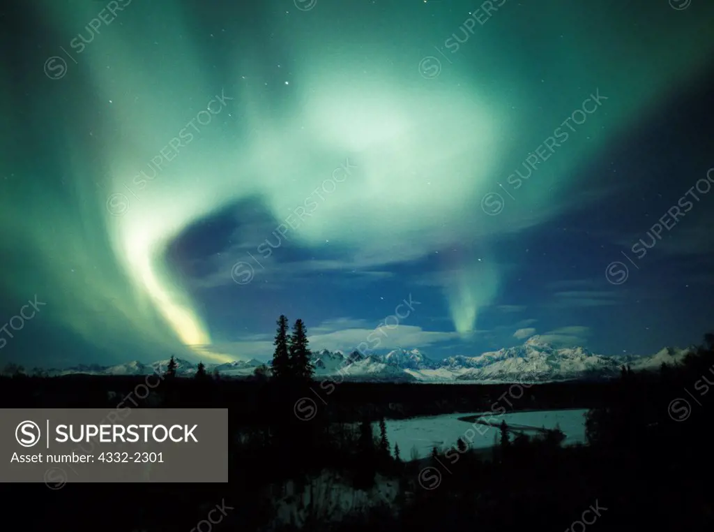 Beautiful display of northern lights over the Alaska Range including Mount McKinley or Denali with the Chulitna River in the foreground, Denali State Park, Alaska.
