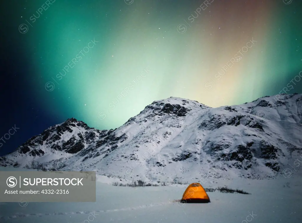 Green aurora above tent and moonlit Talkeetna Mountains near Hatcher Pass, geomagnetic strom during pre-dawn hours of November 6, 2001, Alaska.
