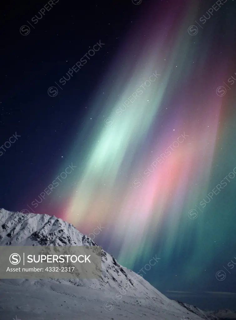 Green, purplish-red and pink aurora above moonlit Marmot Mountain in the Talkeetna Mountains, geomagnetic storm durnig pre-dawn hours of November 6, 2001, Alaska.