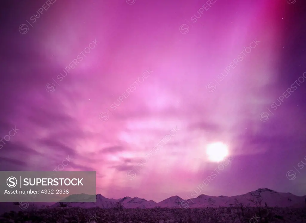 Purplish-pink aurora with moon and clouds above the Chugach Mountains south of Tahneta Pass, geomagnetic storm on morning of November 20, 2003, Alaska.