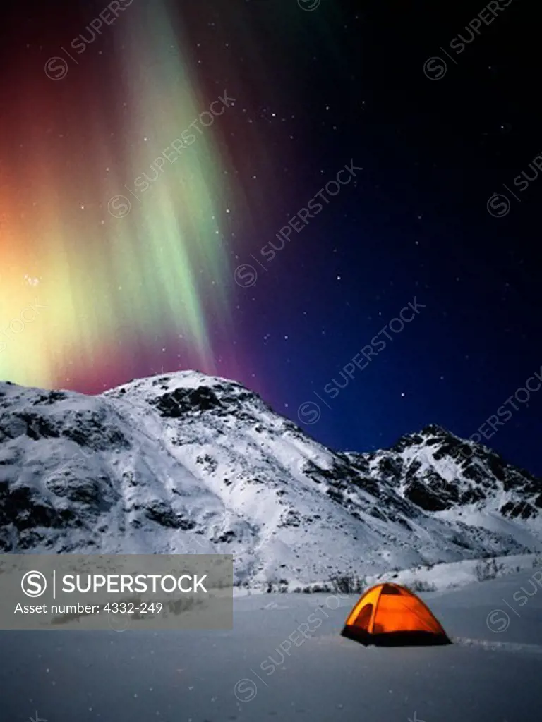 USA, Alaska, Hatcher Pass, Tent with green and red aurora above moonlit Talkeetna Mountains