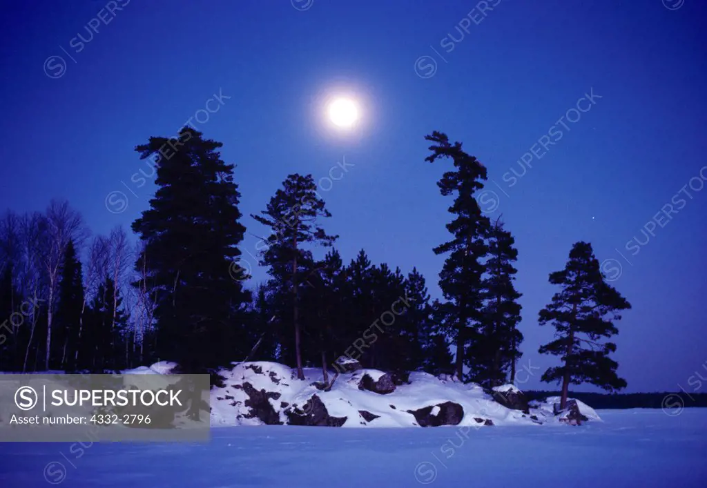 Full moon rising over Voyageur Island on a -30 degree Celsius January evening, Nym Lake, Quetico Provincial Park, Ontraio, Canada.