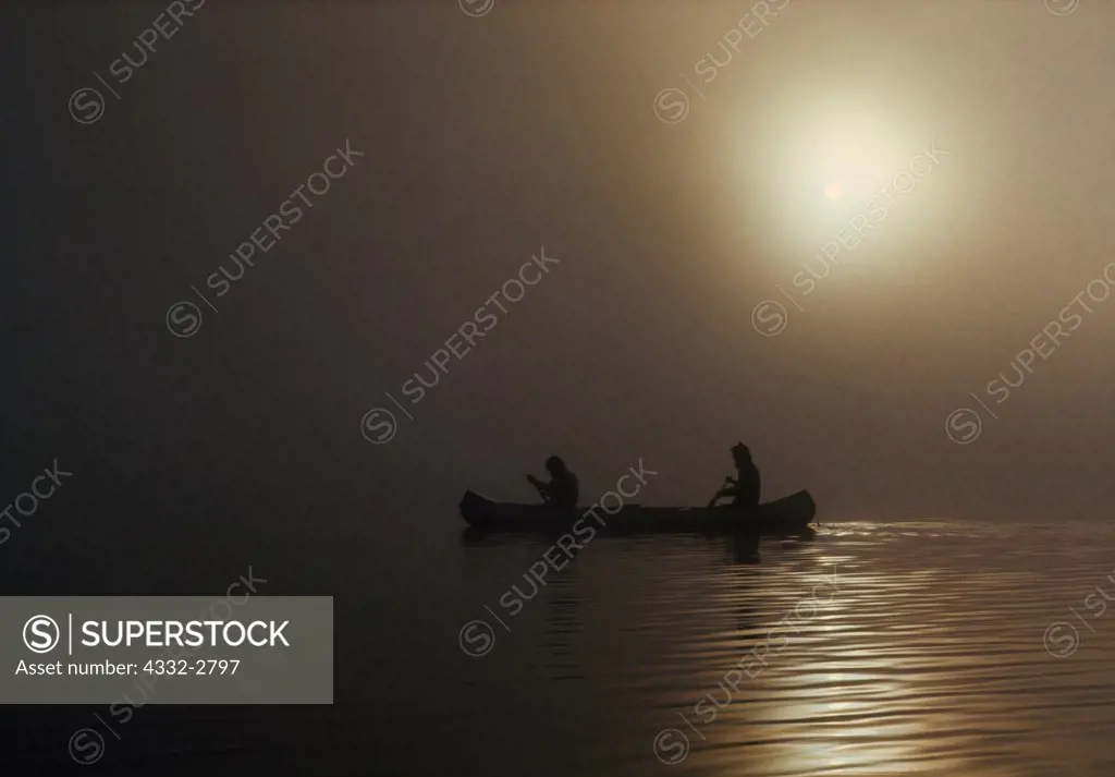 Canoeing Sturgeon Lake in morning mist, Quetico Provincial Park, Ontario, Canada.