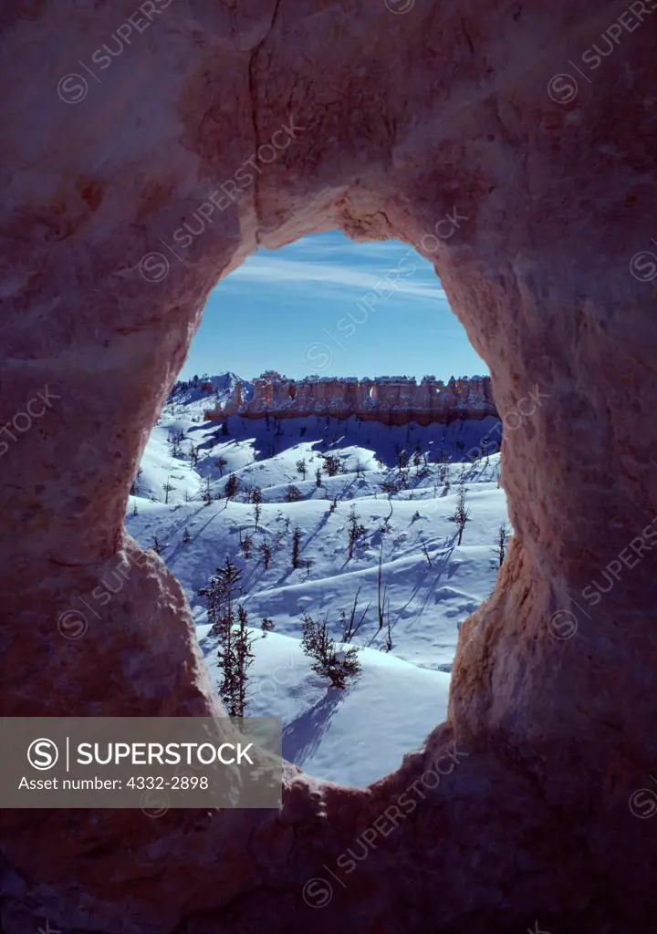 The Chinese Wall viewed in winter through natural window in Claron Formation limestone, Fairlyland Loop, Bryce Canyon National Park, Utah.