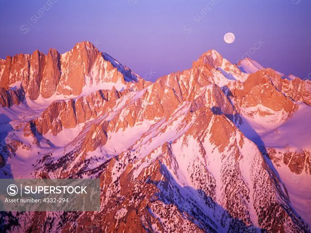 Aerial view of full moon setting beyond Mount Russell with 14,495 foot Mount Whitney to left. Taken during sunrise over Inyo National Forest with Sequoia National Park beyond, California.