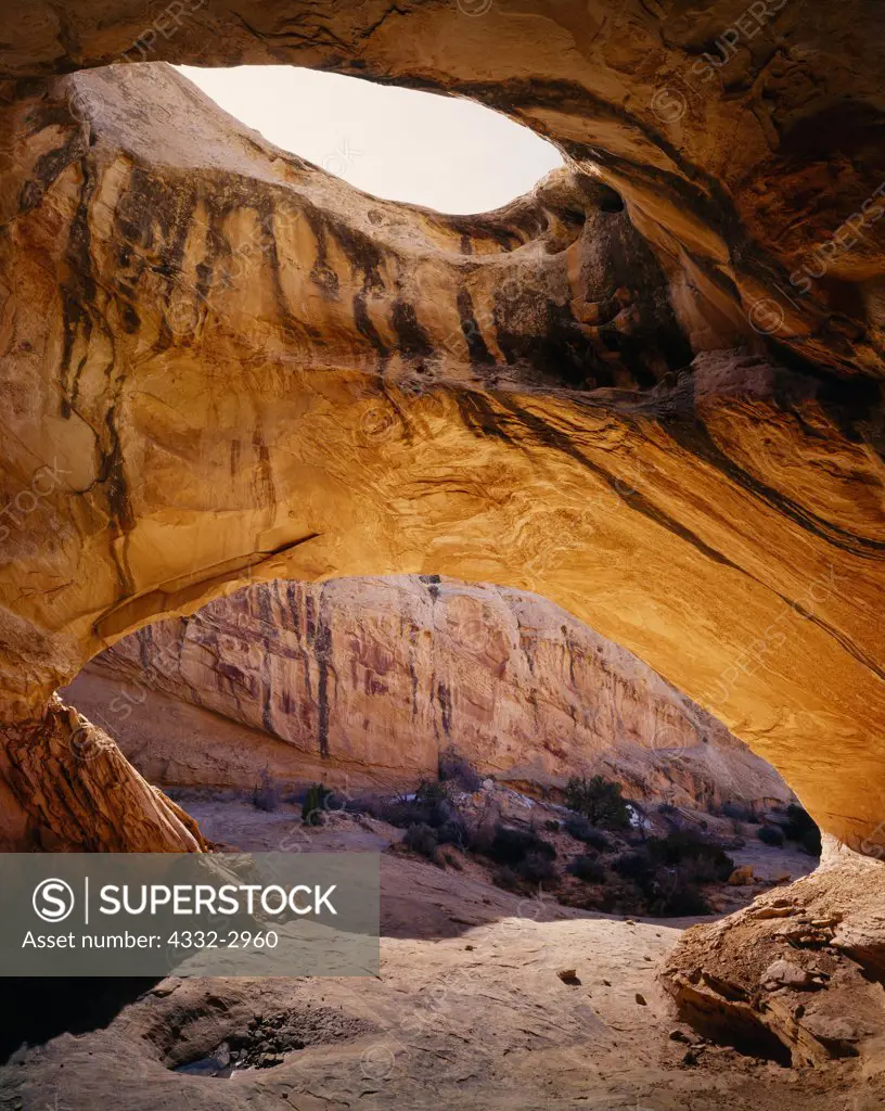 Desert varnish on sandstone walls below a large alcove arch, San Rafael Reef, Utah.