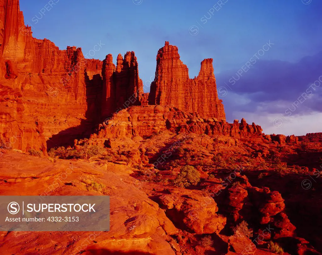 Sunset illuminating the Fisher Towers, erosional spires capped with harder Moenkopi Formation sandstone with softer Cutler Formation sandstones, mudstones and conglomerate below, Utah.