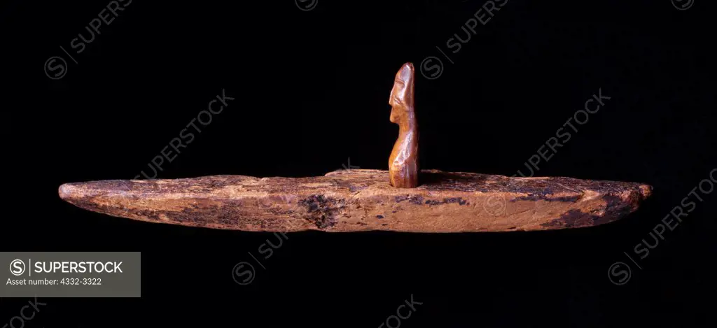 USA, Alaska, St. Lawrence Island, Okvik ivory human figure in wooden kayak, circa 200 BC to 100 AD